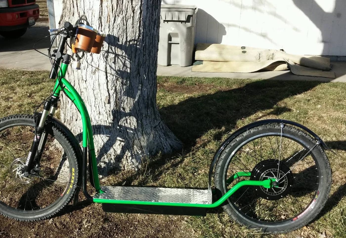 Green NF scooter from 2016 parked beside a tree