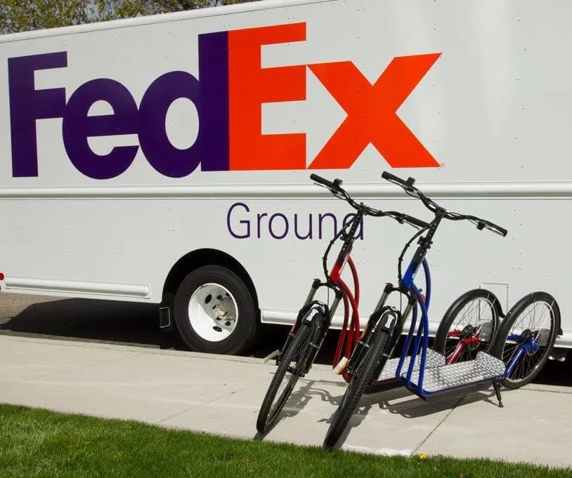 Two NF scooters beside a FedEx Ground truck